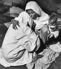 A woman holding her baby comforting a widow